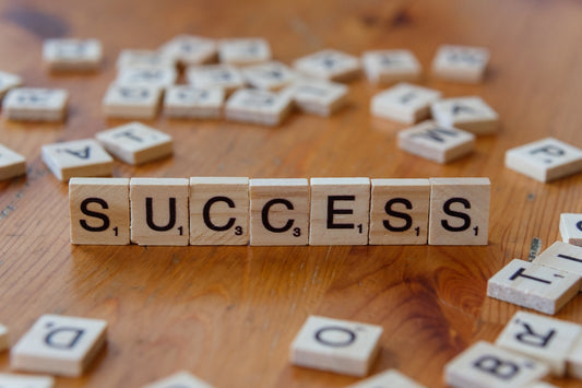 Scrabble tiles spelling out the word success on a wooden table